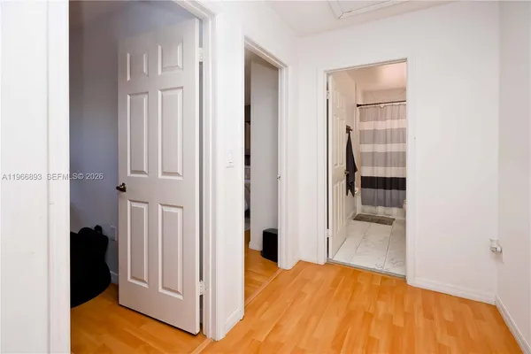 a view of a bedroom with wooden floor and bathroom