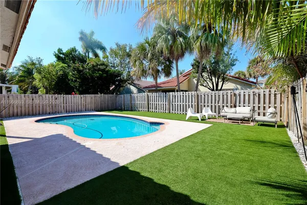 a view of a backyard with a small swimming pool and wooden fence