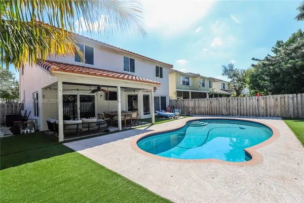 a view of a house with swimming pool and sitting area