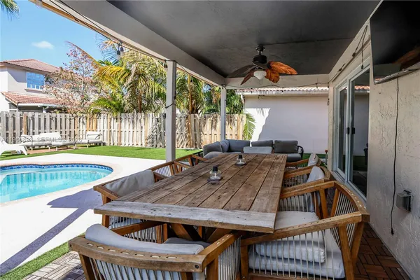 a roof deck with a dining table and chairs with wooden floor