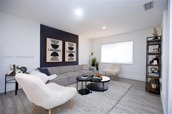 a living room with furniture and a wooden floor