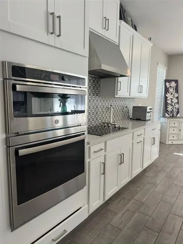 a view of a hallway with wooden floor and stairs