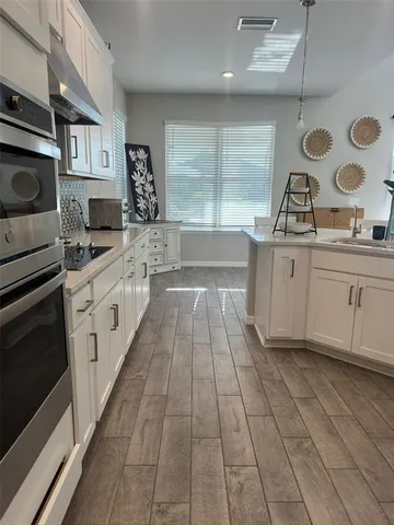 a view of a hallway with wooden floor and staircase
