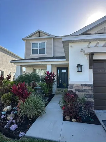 a front view of a house with plants