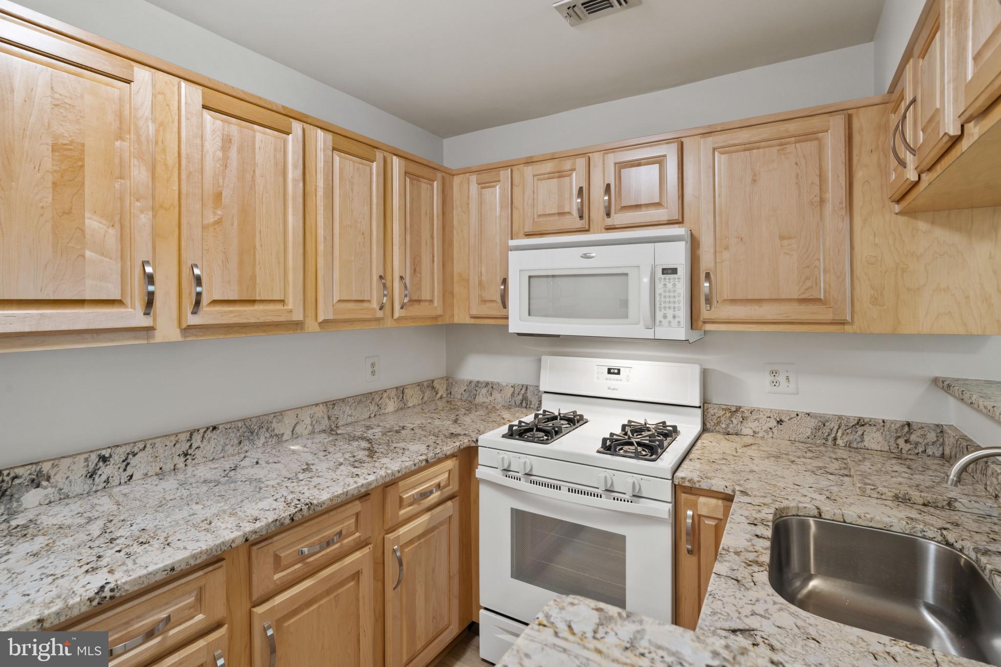 6832 Hayley Ridge Way, Unit D Baltimore, MD 21209 - Photo 6 of 33 a kitchen with granite countertop cabinets stainless steel appliances and a sink