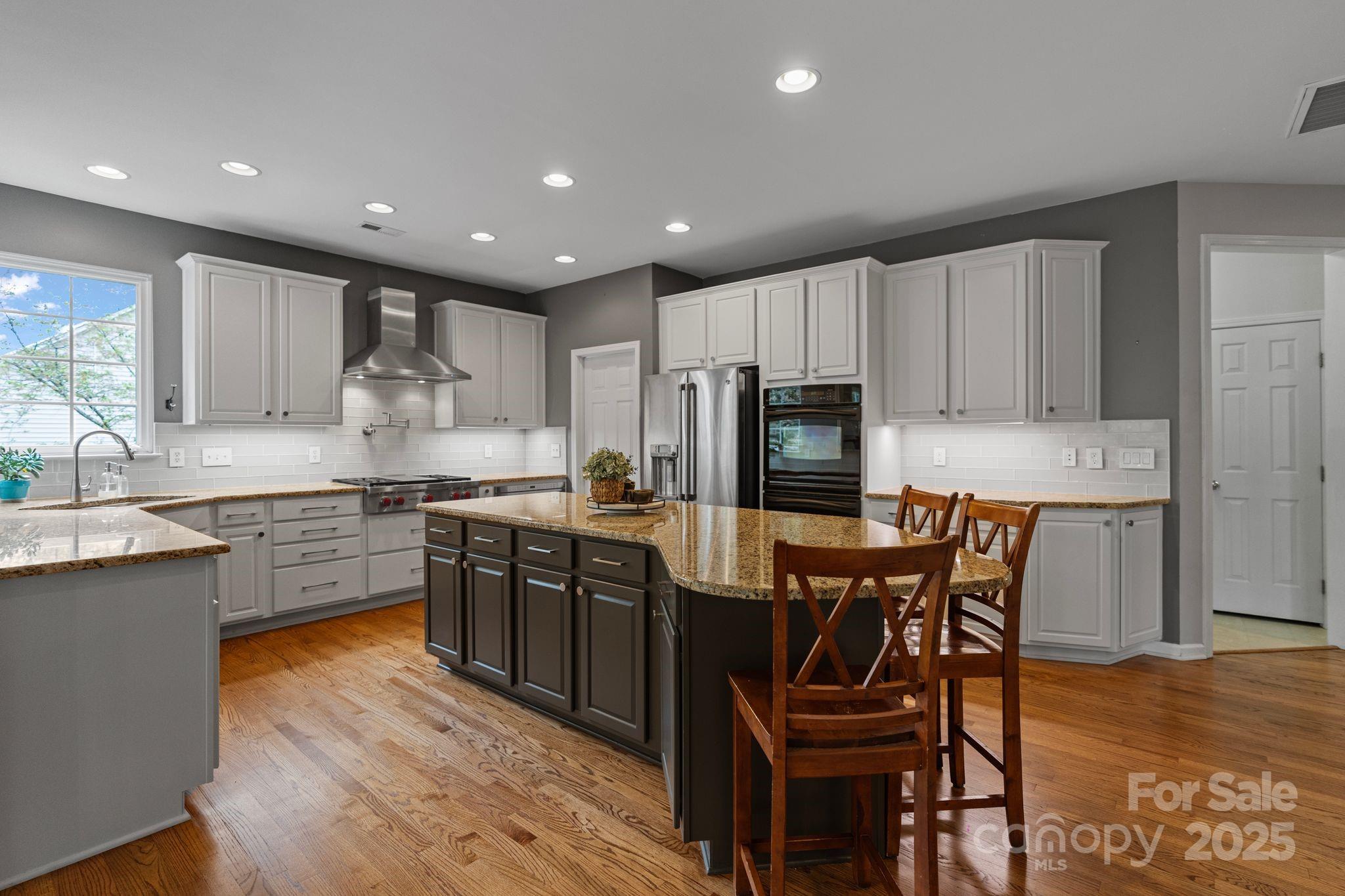 1039 Sharon Lee Avenue Fort Mill, SC 29708 - Photo 17 of 46 a kitchen with stainless steel appliances granite countertop wooden cabinets a dining table and chairs