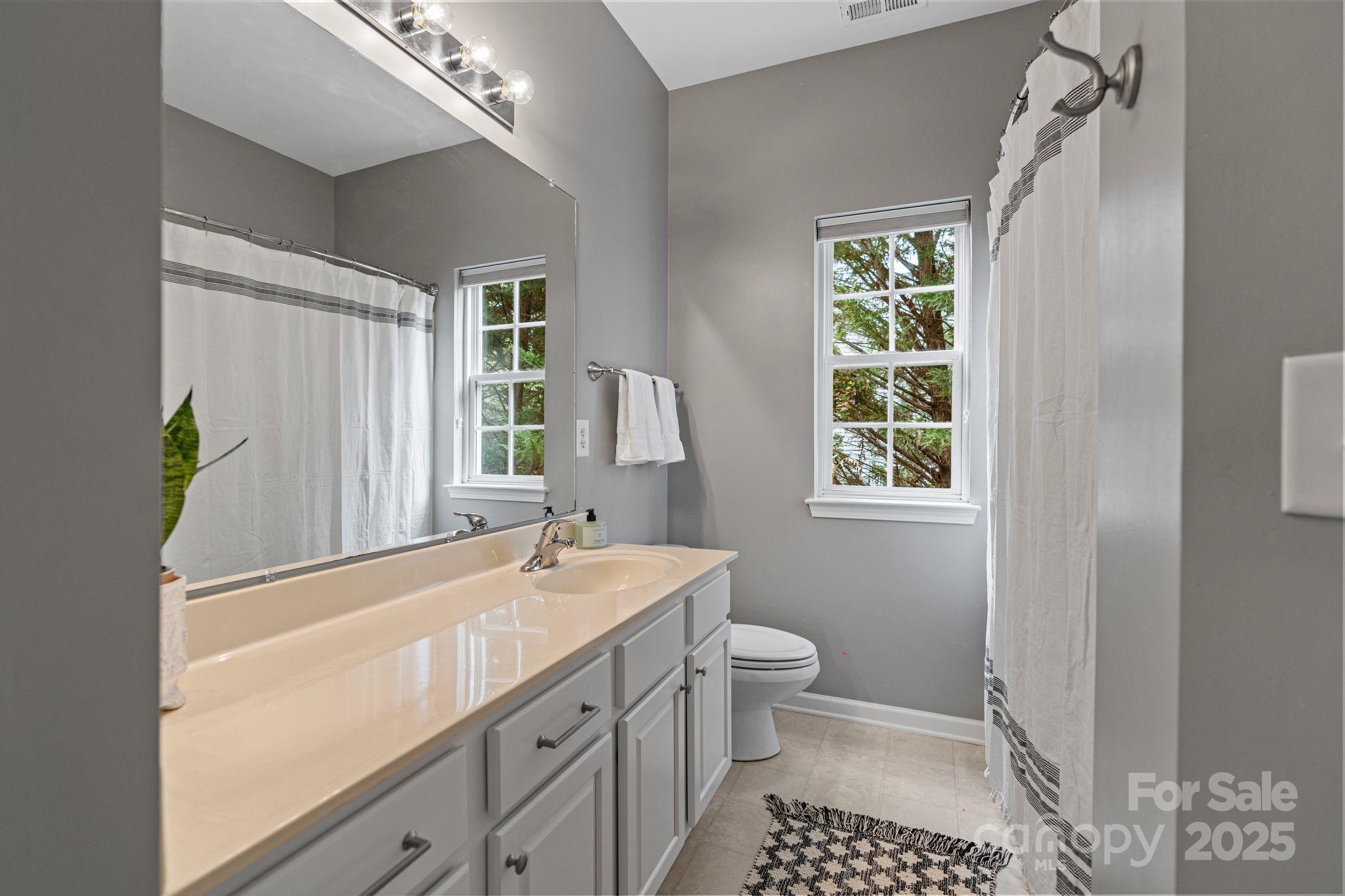 1039 Sharon Lee Avenue Fort Mill, SC 29708 - Photo 27 of 46 a spacious bathroom with a double vanity sink a toilet and a mirror