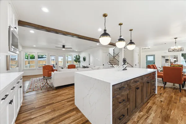 a large kitchen with a counter space a sink appliances and living room view