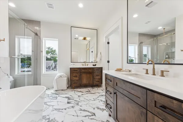 a large bathroom with a sink mirror and a bath tub