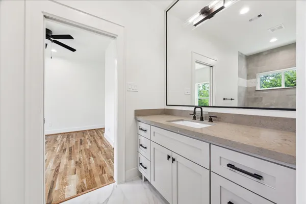 a bathroom with a granite countertop sink and a mirror