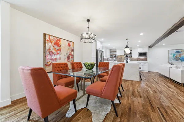 a dining room with furniture a chandelier and wooden floor