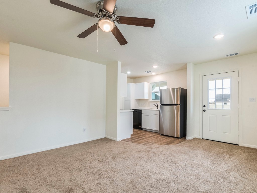 2002 West 2nd Street, Unit 902 Taylor, TX 76574 - Photo 5 of 18 a view of a kitchen with a refrigerator and a ceiling fan