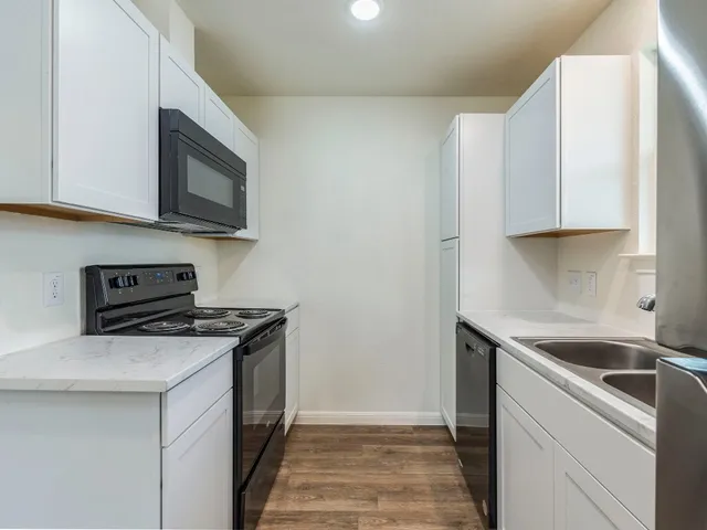 a kitchen with stainless steel appliances granite countertop a sink stove and microwave