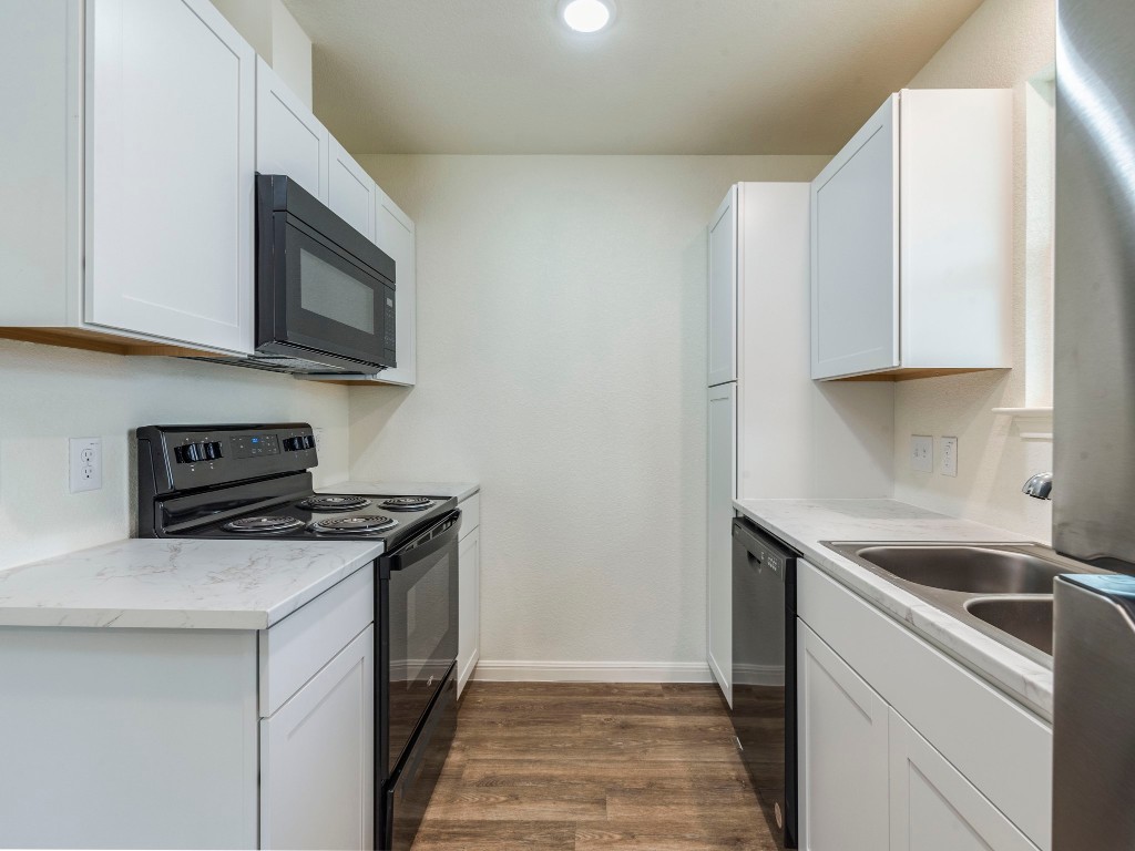 2002 West 2nd Street, Unit 902 Taylor, TX 76574 - Photo 9 of 18 a kitchen with stainless steel appliances granite countertop a sink stove and microwave