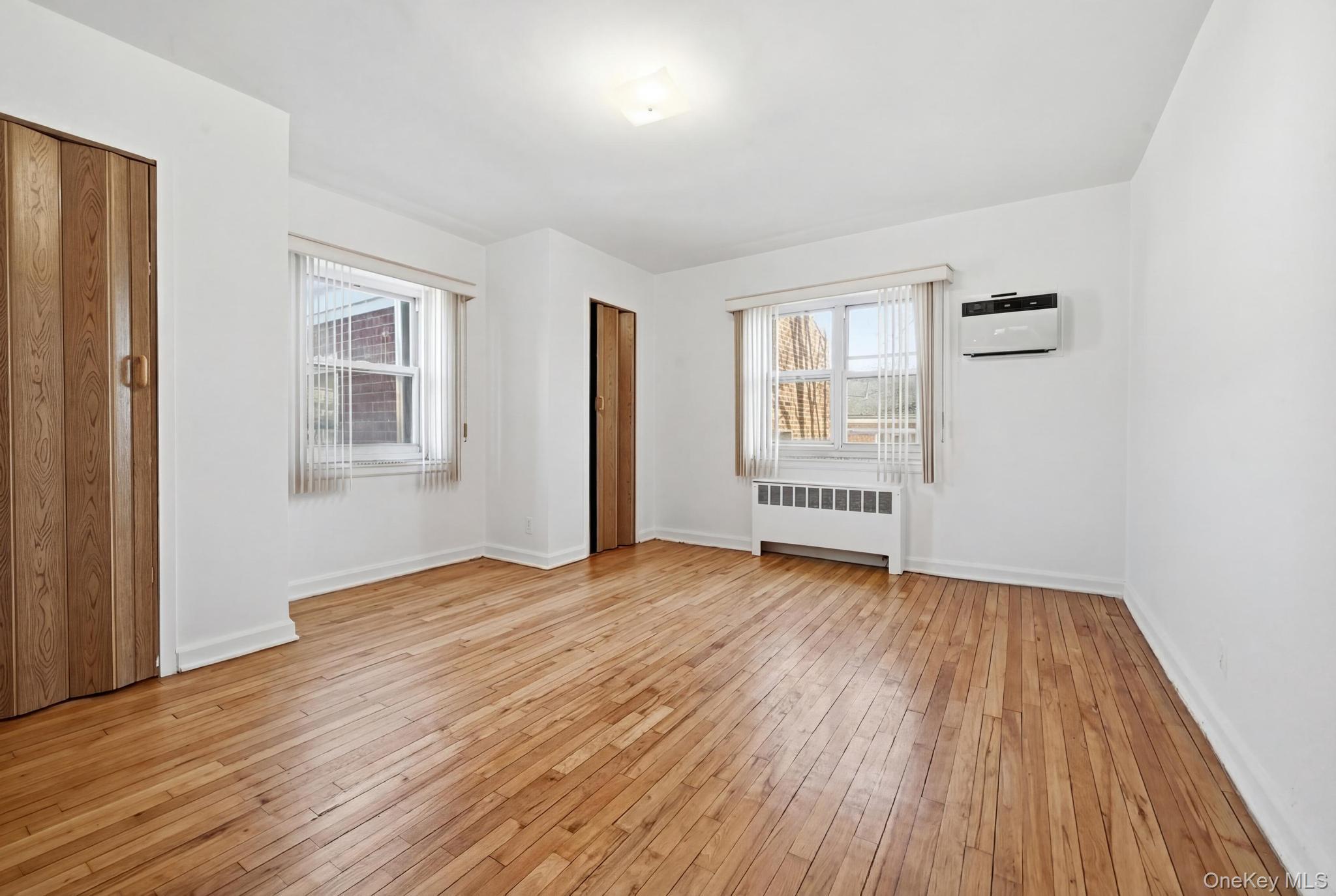 221 South Middle Neck Road, Unit F6 Great Neck, NY 11021 - Photo 13 of 16 a view of an empty room with wooden floor and a window