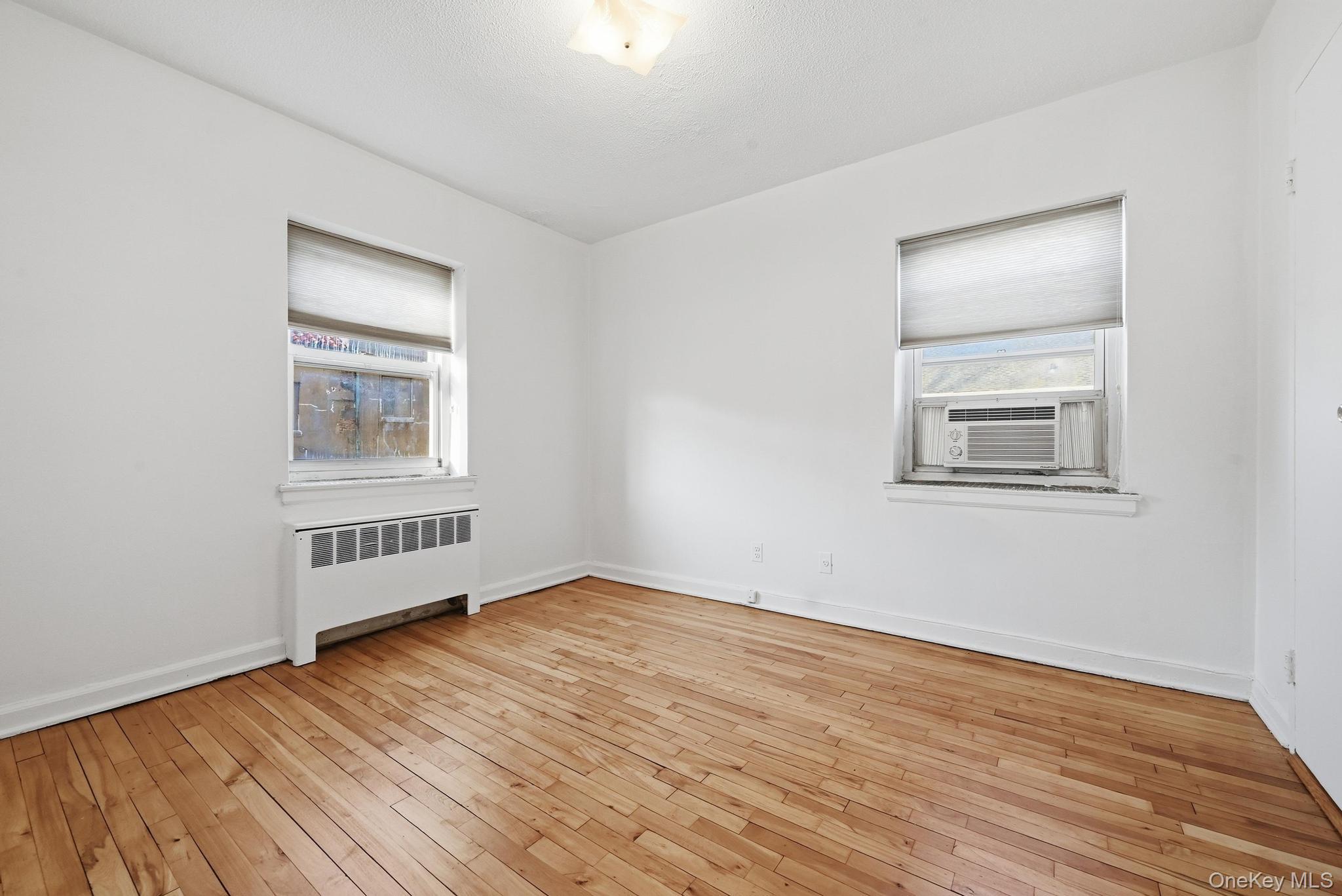 221 South Middle Neck Road, Unit F6 Great Neck, NY 11021 - Photo 14 of 16 a view of an empty room with wooden floor and a window