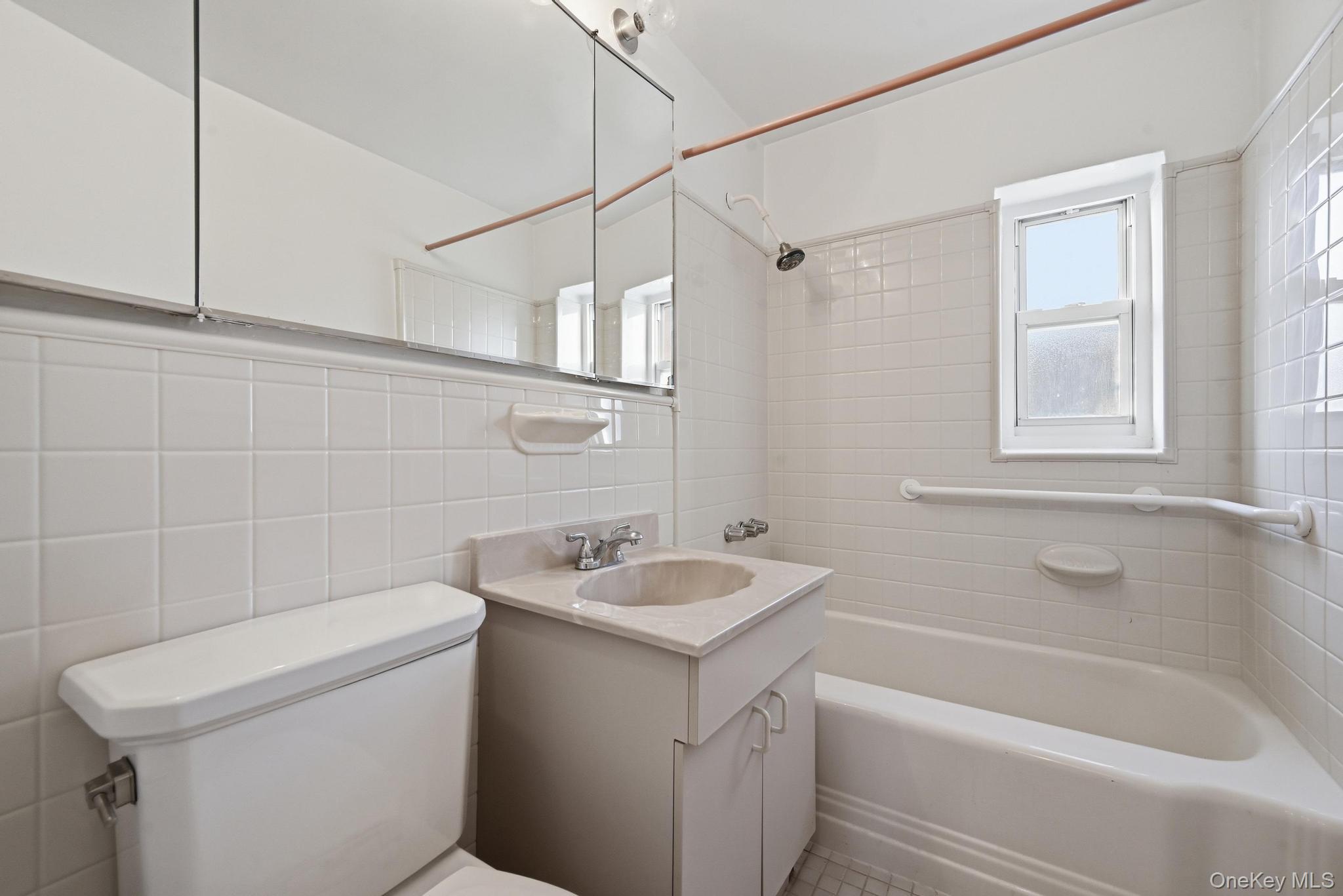 221 South Middle Neck Road, Unit F6 Great Neck, NY 11021 - Photo 15 of 16 a bathroom with a sink a toilet and shower