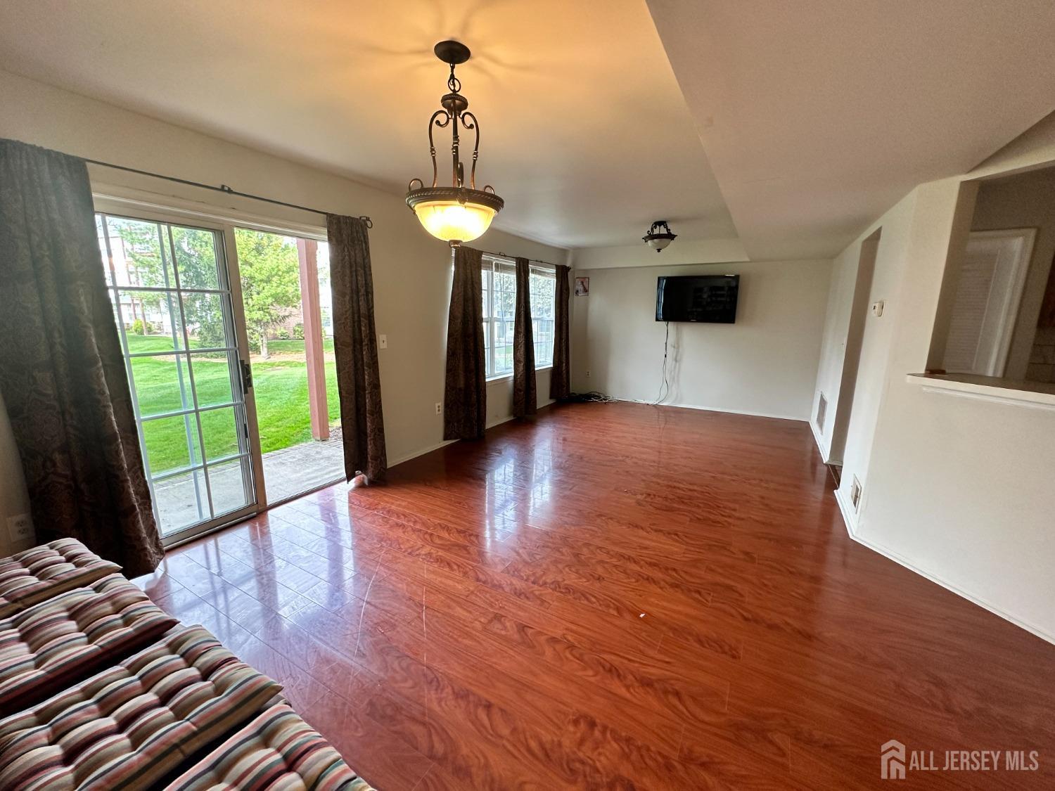 407 Plymouth Road North Brunswick, NJ 08902 - Photo 5 of 16 a view of a livingroom with wooden floor and a ceiling fan