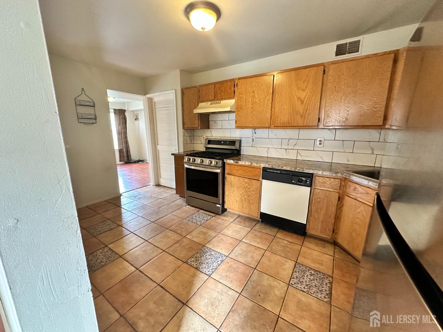407 Plymouth Road North Brunswick, NJ 08902 - Photo 6 of 16 a kitchen with stainless steel appliances granite countertop a stove a sink and a refrigerator