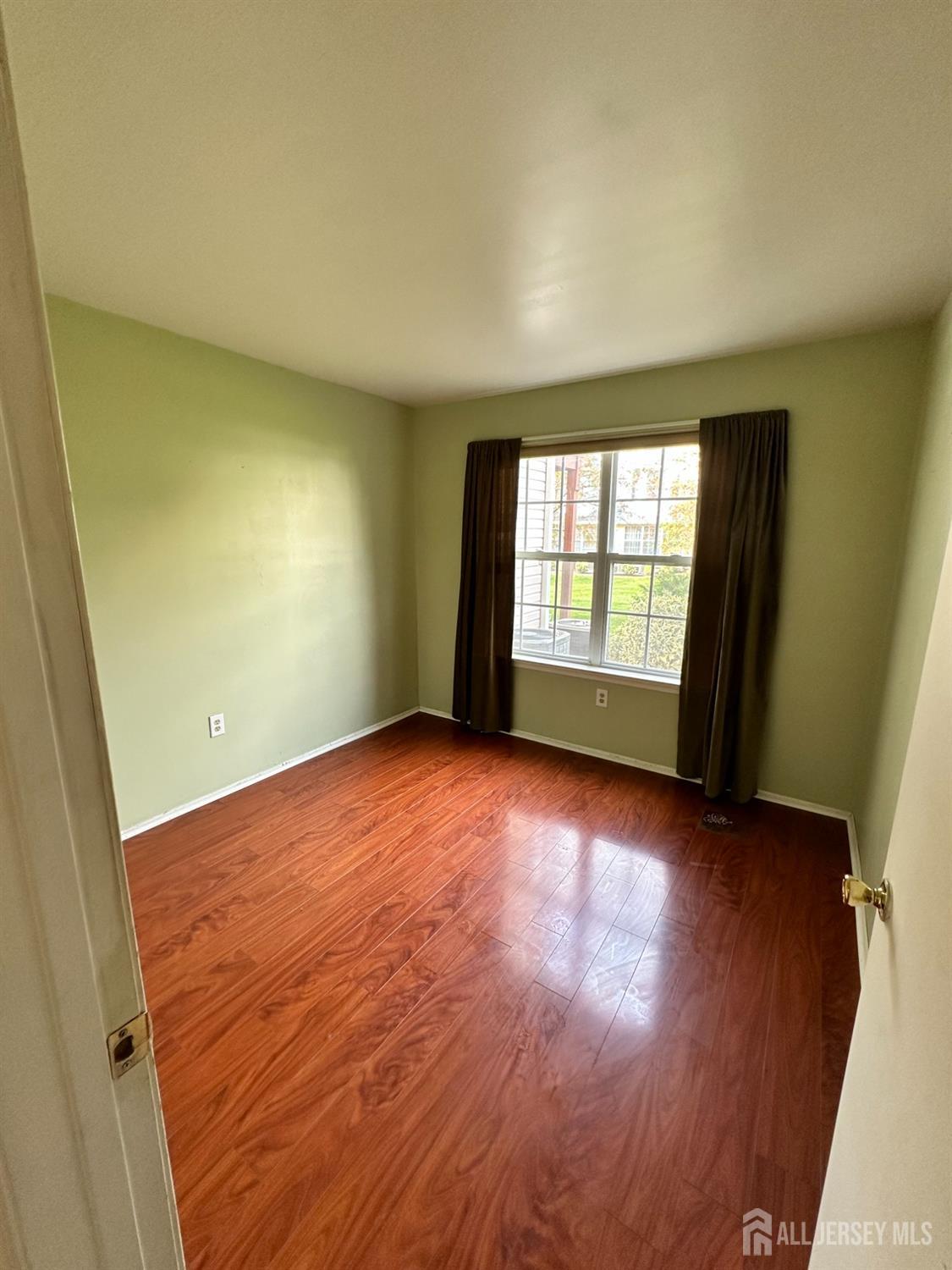 407 Plymouth Road North Brunswick, NJ 08902 - Photo 7 of 16 an empty room with wooden floor and windows