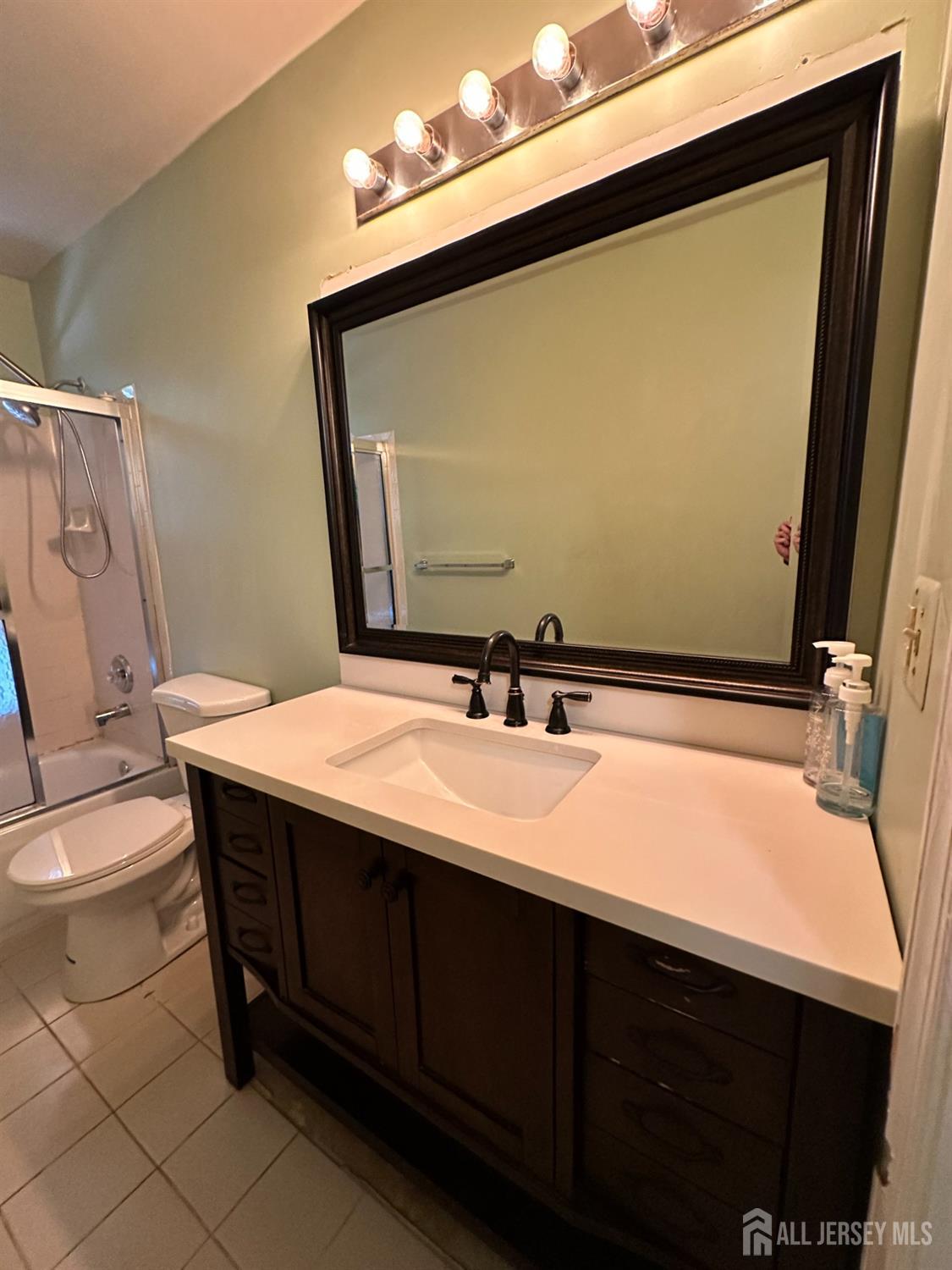 407 Plymouth Road North Brunswick, NJ 08902 - Photo 10 of 16 a bathroom with a sink a toilet and mirror