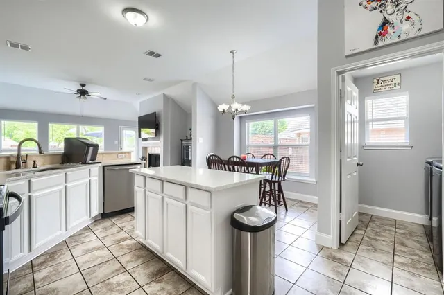 a kitchen with a stove a sink cabinets and appliances