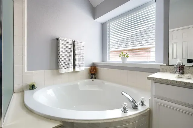 a white bath tub sitting in a bathroom next to a window