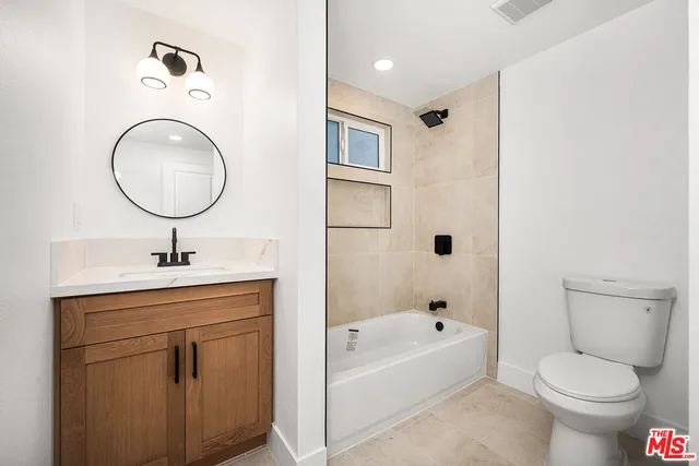 a bathroom with a bathtub a toilet a sink and mirror