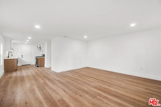 a view of a kitchen with kitchen island wooden floor center island and stainless steel appliances