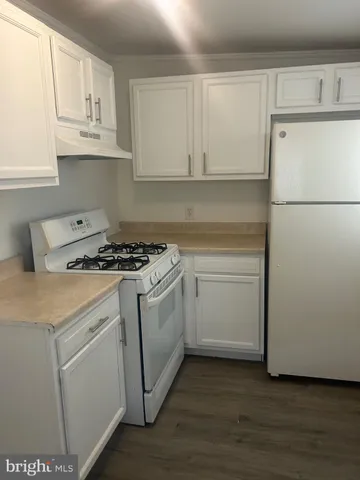 a kitchen with white cabinets and white appliances