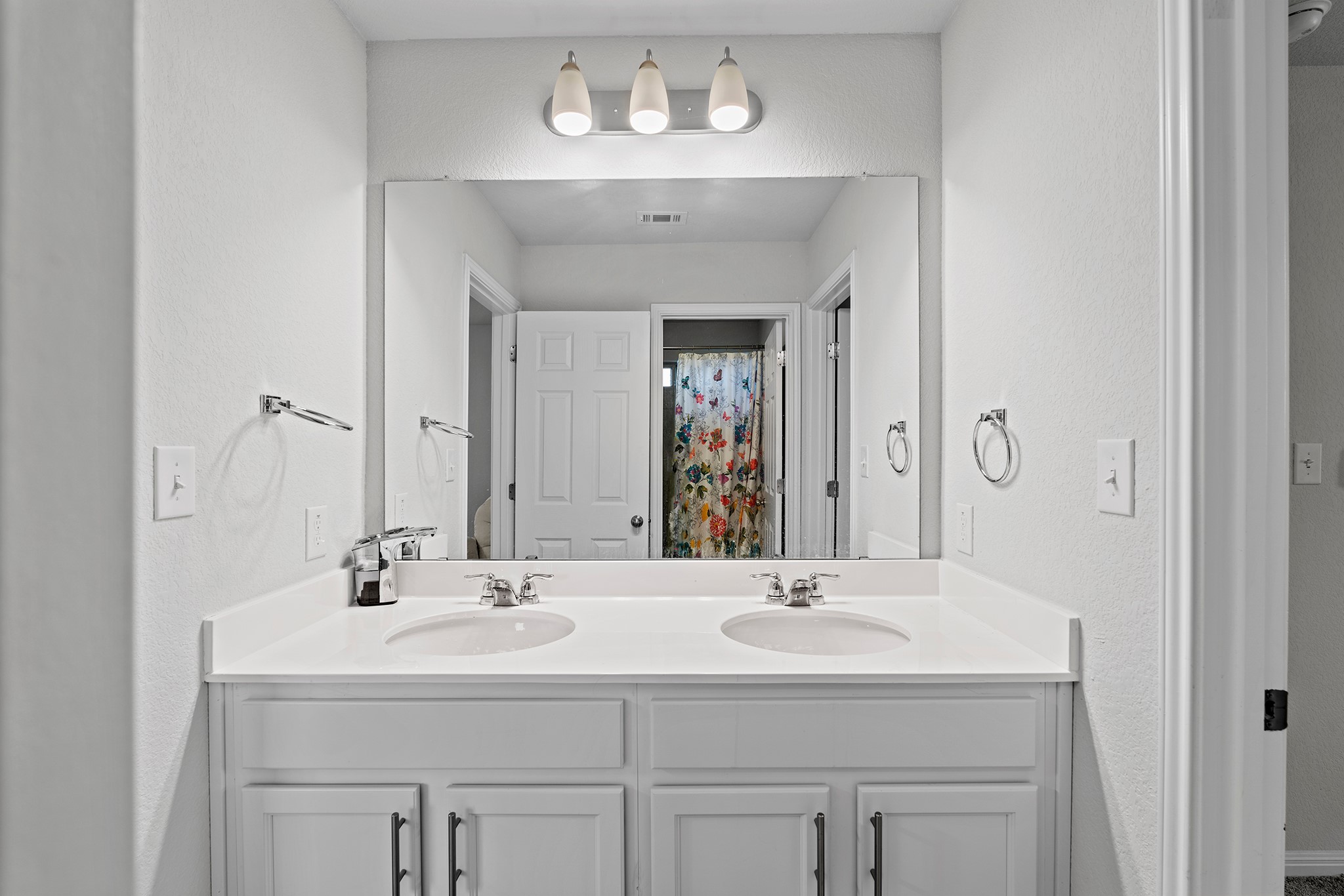 133 Caney Cove Leander, TX 78641 - Photo 22 of 30 Bathroom with double vanity, curtained shower, visible vents, and a sink