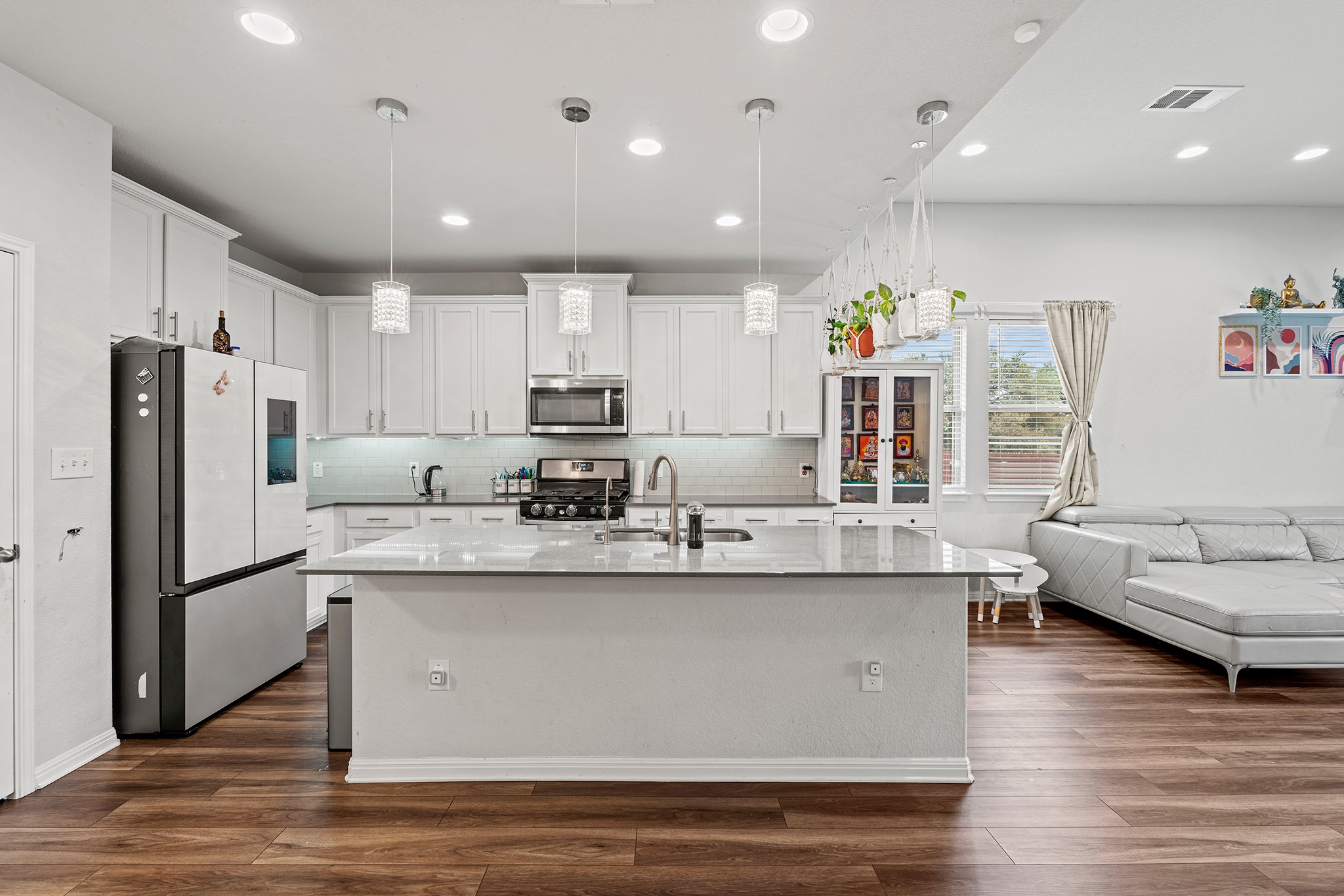 133 Caney Cove Leander, TX 78641 - Photo 2 of 30 Kitchen featuring appliances with stainless steel finishes, visible vents, a sink, and dark wood-type flooring