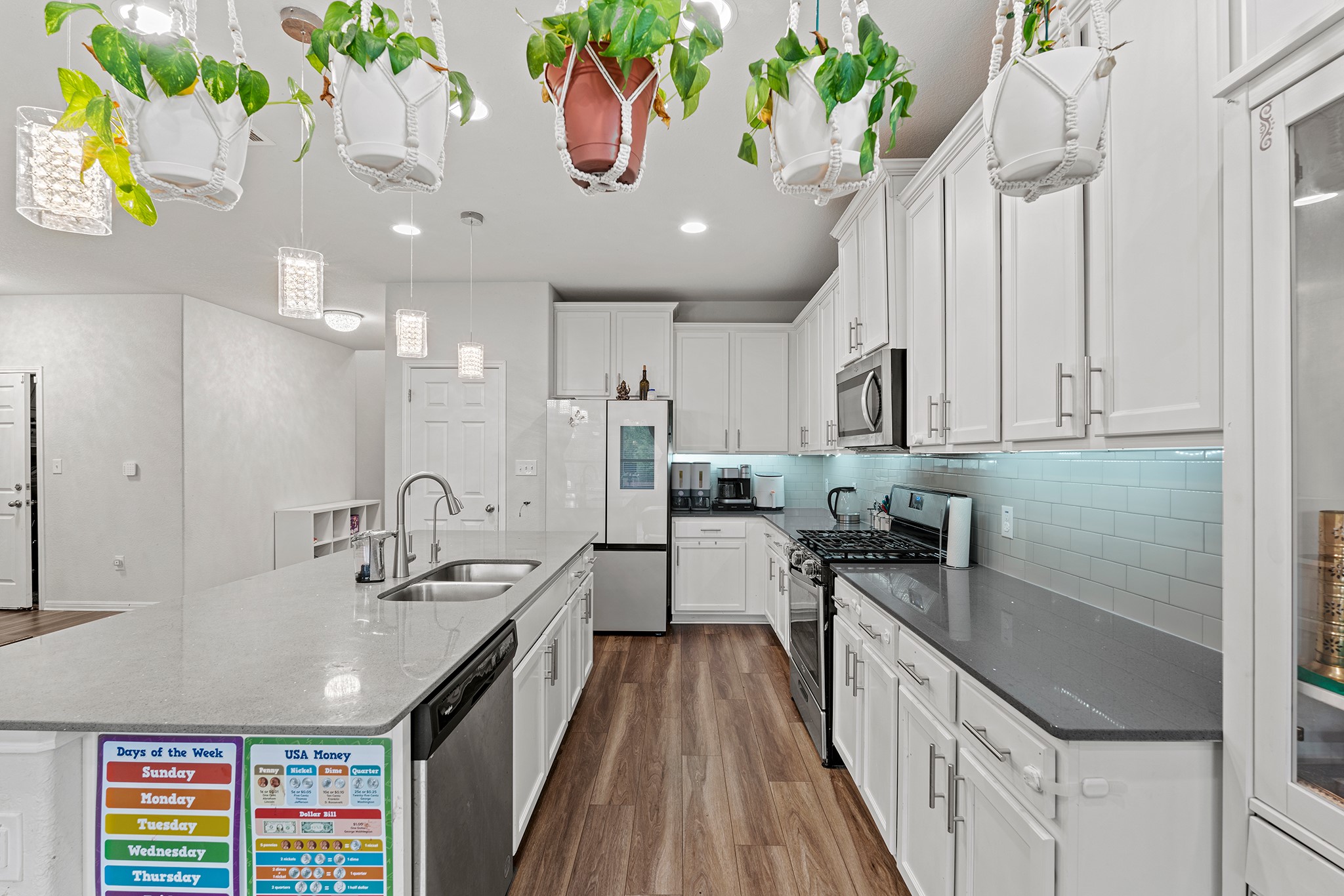 133 Caney Cove Leander, TX 78641 - Photo 3 of 30 Kitchen with tasteful backsplash, appliances with stainless steel finishes, dark wood-type flooring, white cabinets, and a sink