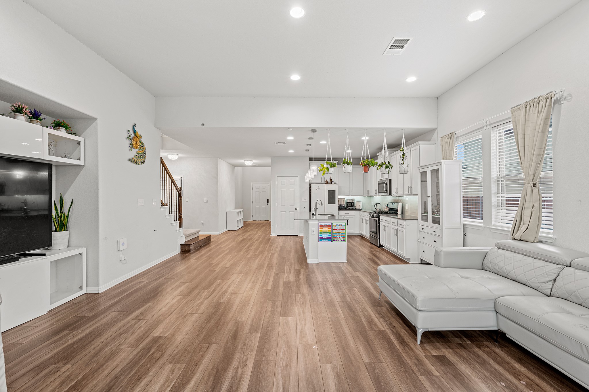 133 Caney Cove Leander, TX 78641 - Photo 5 of 30 Living room featuring light wood finished floors, recessed lighting, visible vents, baseboards, and stairs