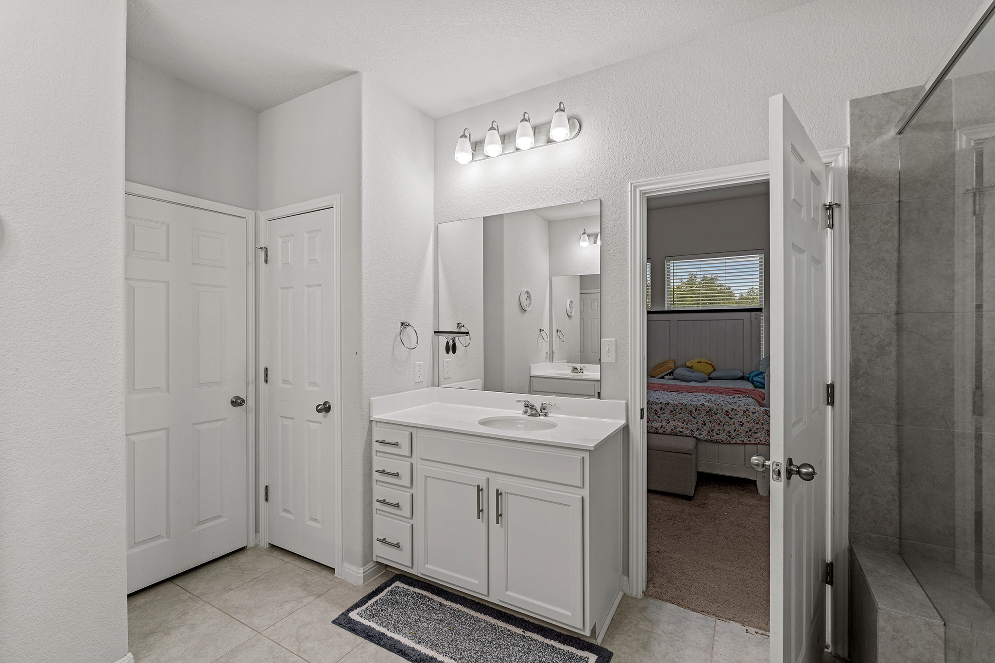 133 Caney Cove Leander, TX 78641 - Photo 8 of 30 Bathroom featuring vanity, a tile shower, connected bathroom, and tile patterned floors