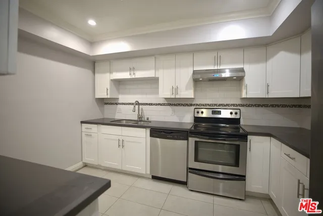 a kitchen with stainless steel appliances granite countertop a sink and a stove
