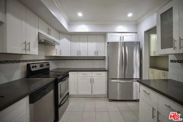 a kitchen with granite countertop a refrigerator stove and sink