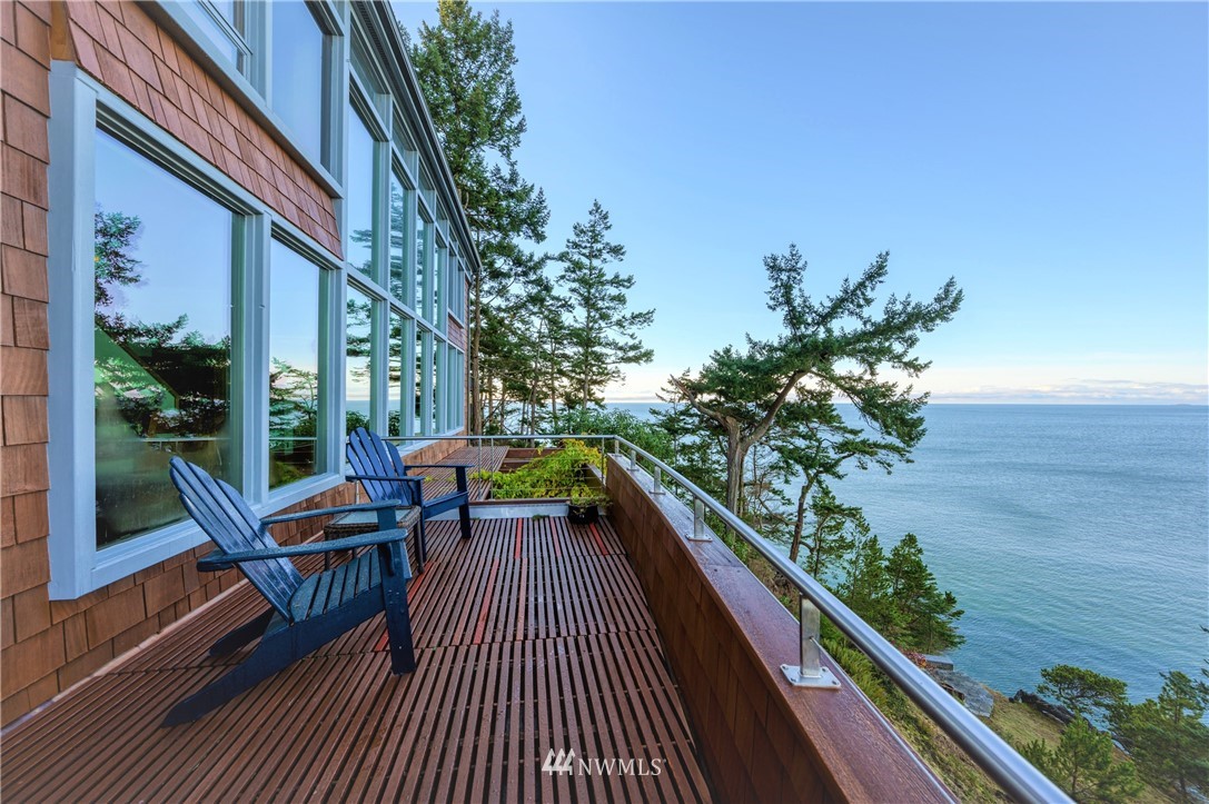 a balcony with wooden floor table and chairs