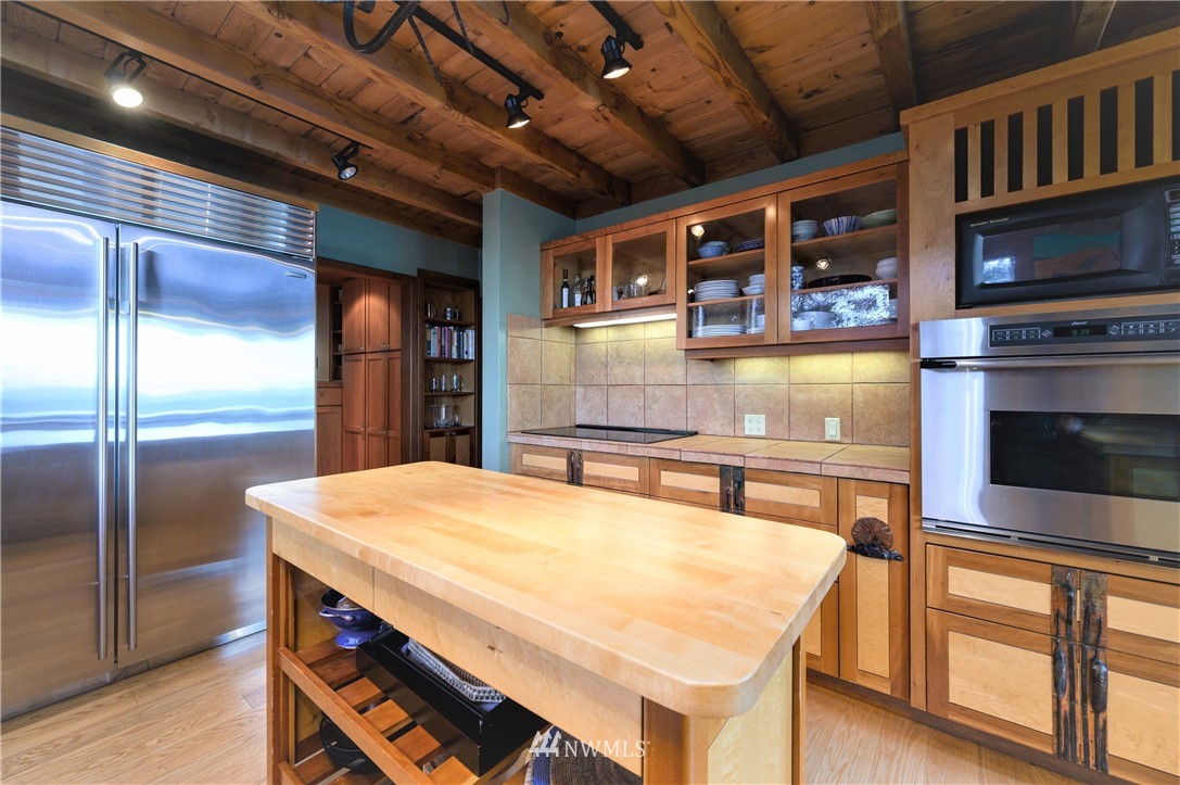14114 Ervine Road Anacortes, WA 98221 - Photo 13 of 40 a kitchen with stainless steel appliances kitchen island granite countertop a table chairs and a refrigerator