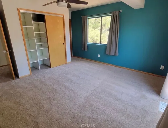 an empty room with closet and windows