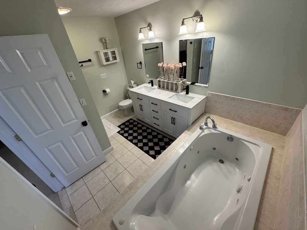45 Crescent Road, Unit 45 Needham, MA 02494 - Photo 7 of 25 a bathroom with a sink a toilet a mirror and shower