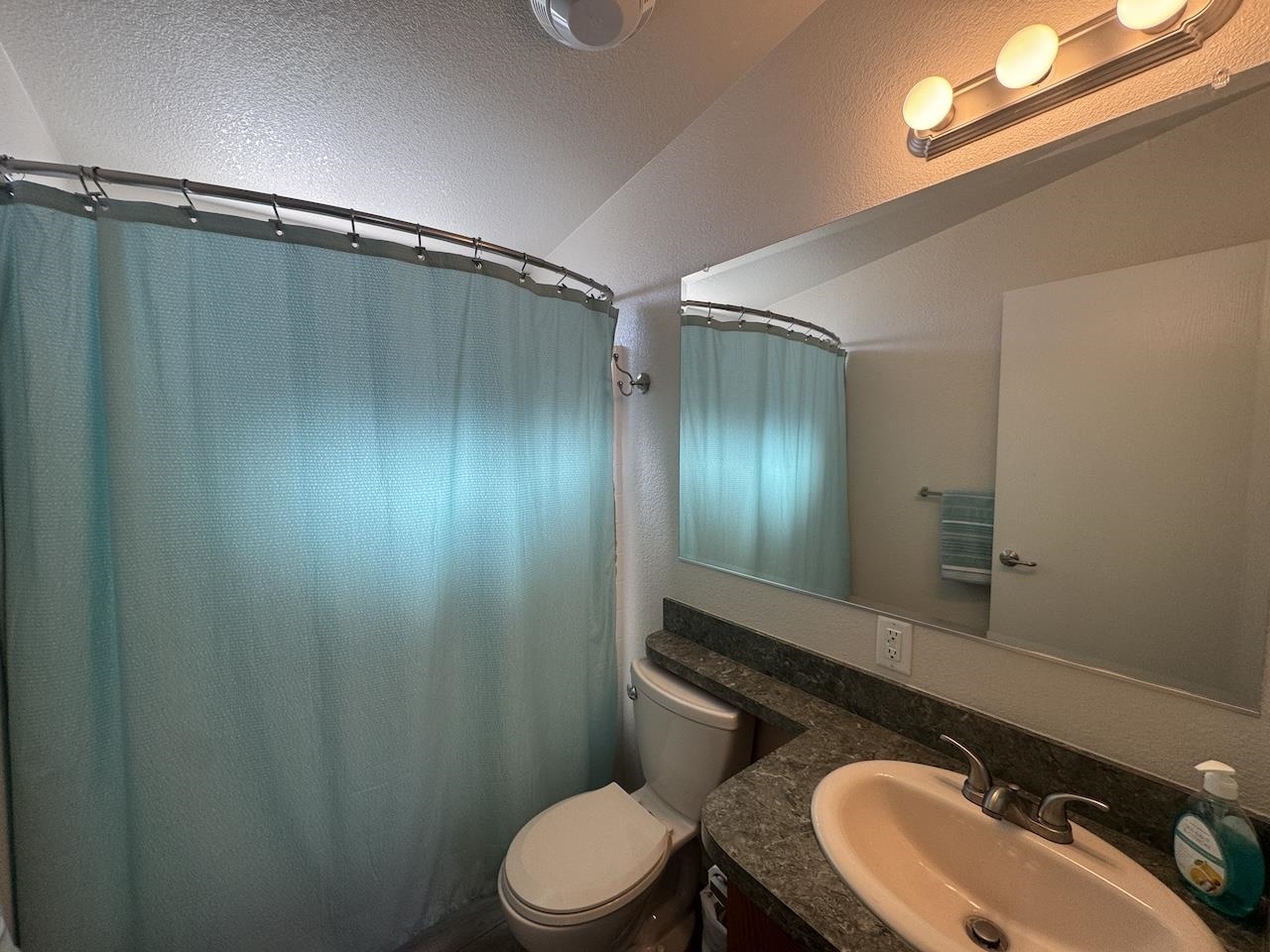 352 Wofford Road, Unit 4 Bishop, CA 93514 - Photo 22 of 40 Bathroom featuring a shower with shower curtain, vanity, and a textured wall