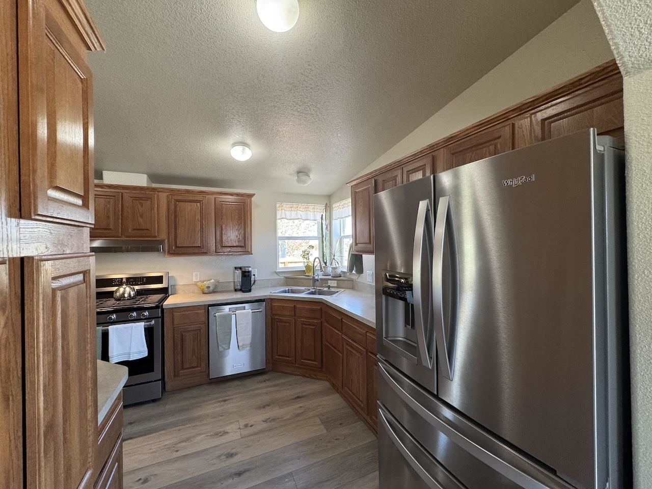 352 Wofford Road, Unit 4 Bishop, CA 93514 - Photo 5 of 40 Kitchen with stainless steel appliances, light countertops, dark wood-style floors, and wood finish cabinets