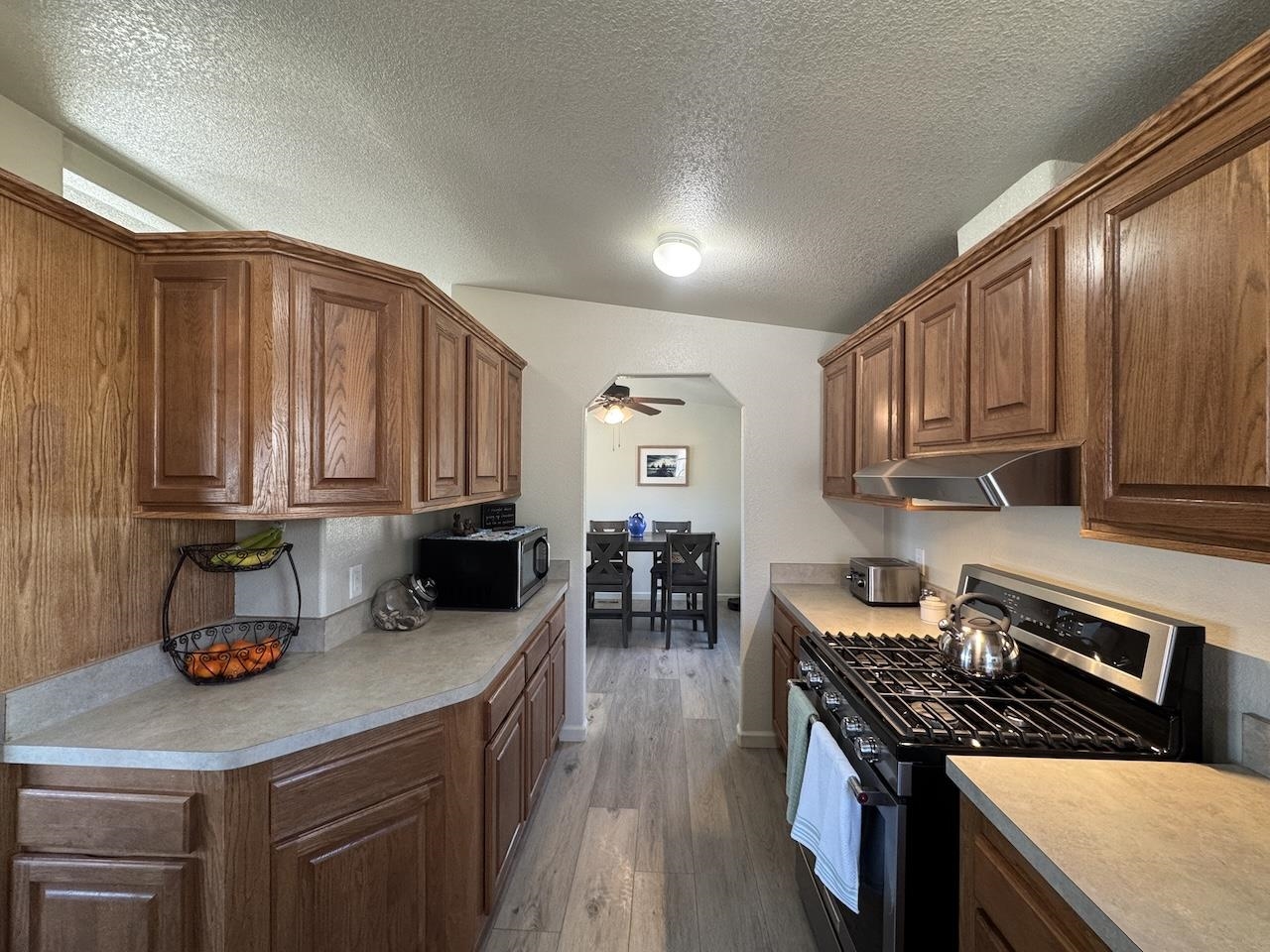 352 Wofford Road, Unit 4 Bishop, CA 93514 - Photo 9 of 40 Kitchen with stainless steel appliances, dark wood-type flooring, a textured ceiling, light countertops, and ceiling fan