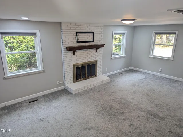 a view of empty room with windows and fireplace