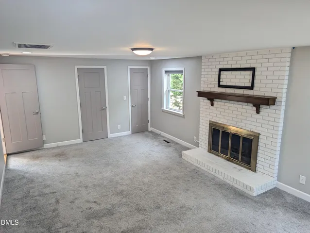 a living room with a fireplace and a window