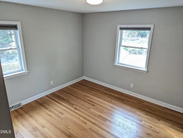 a view of a room with wooden floor and windows