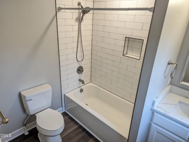 a white toilet sitting next to a bath tub