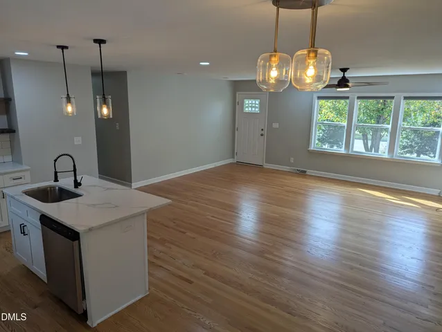a view of a kitchen with wooden floor and a sink