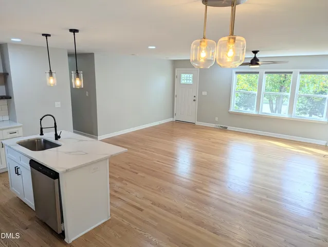 a view of a kitchen with a sink wooden floor and a chandelier